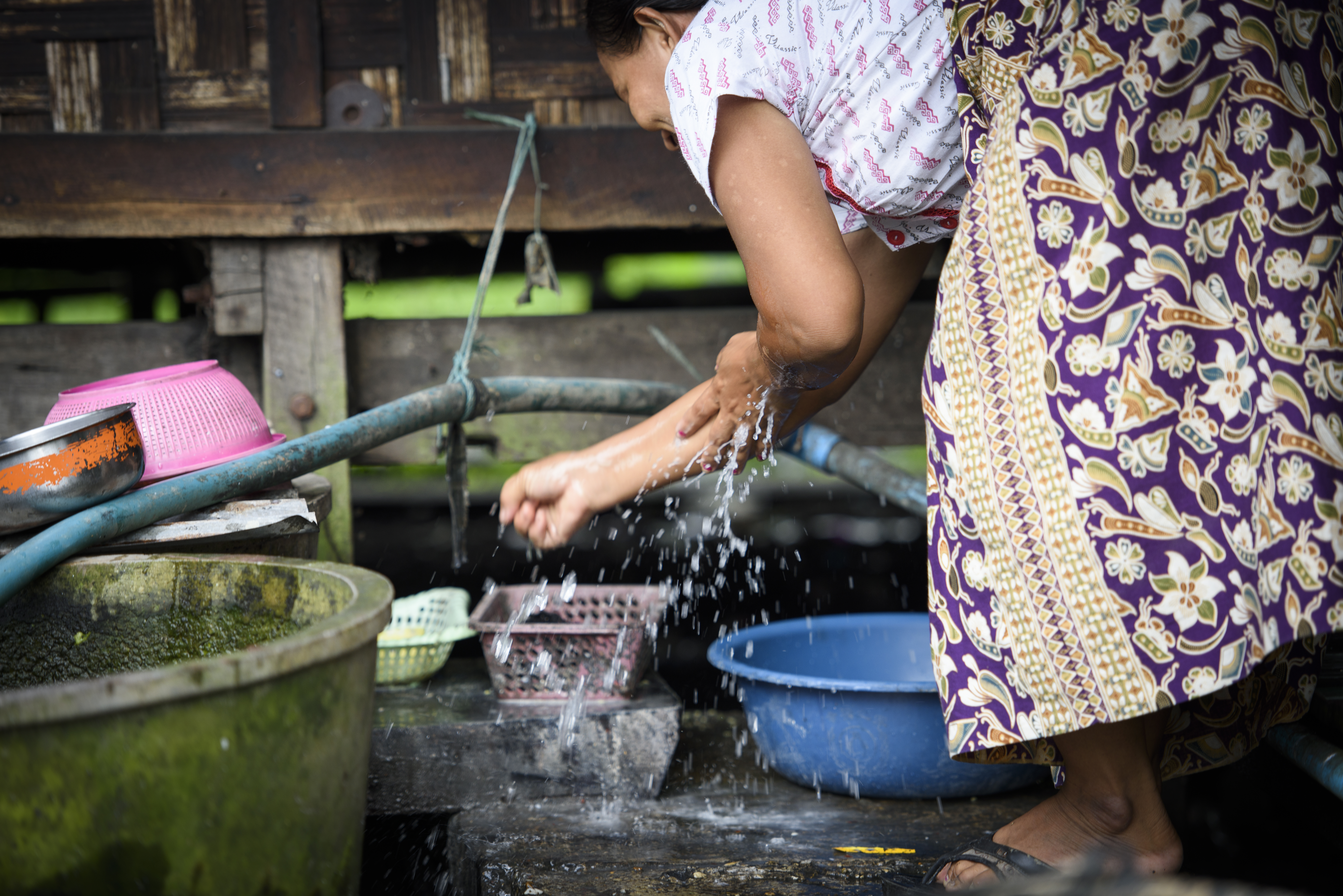 En man med ett barn i famnen tittar in i kameran, bredvid honom står ett lite äldre barn. 