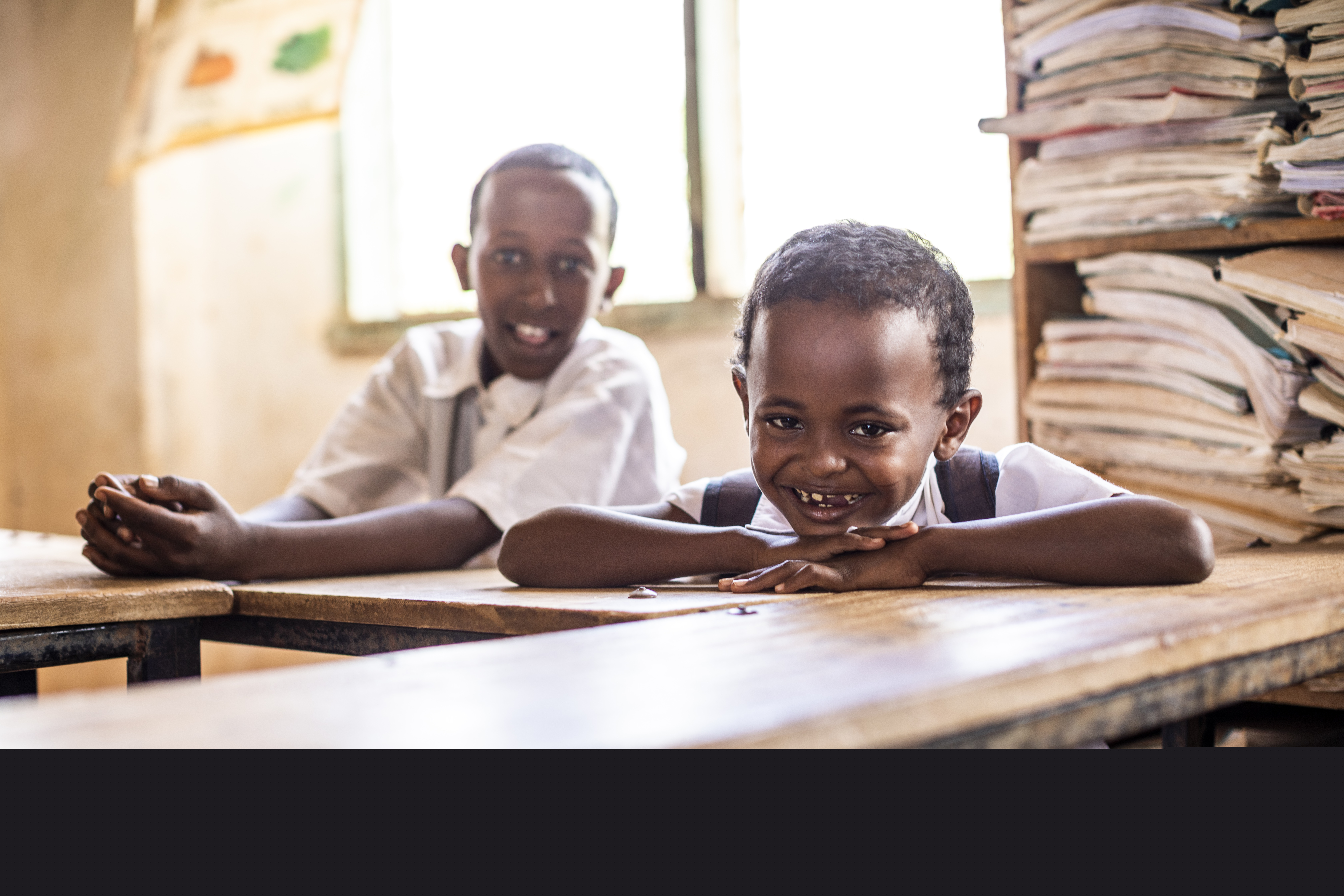 Två pojkar sitter i ett klassrum. 