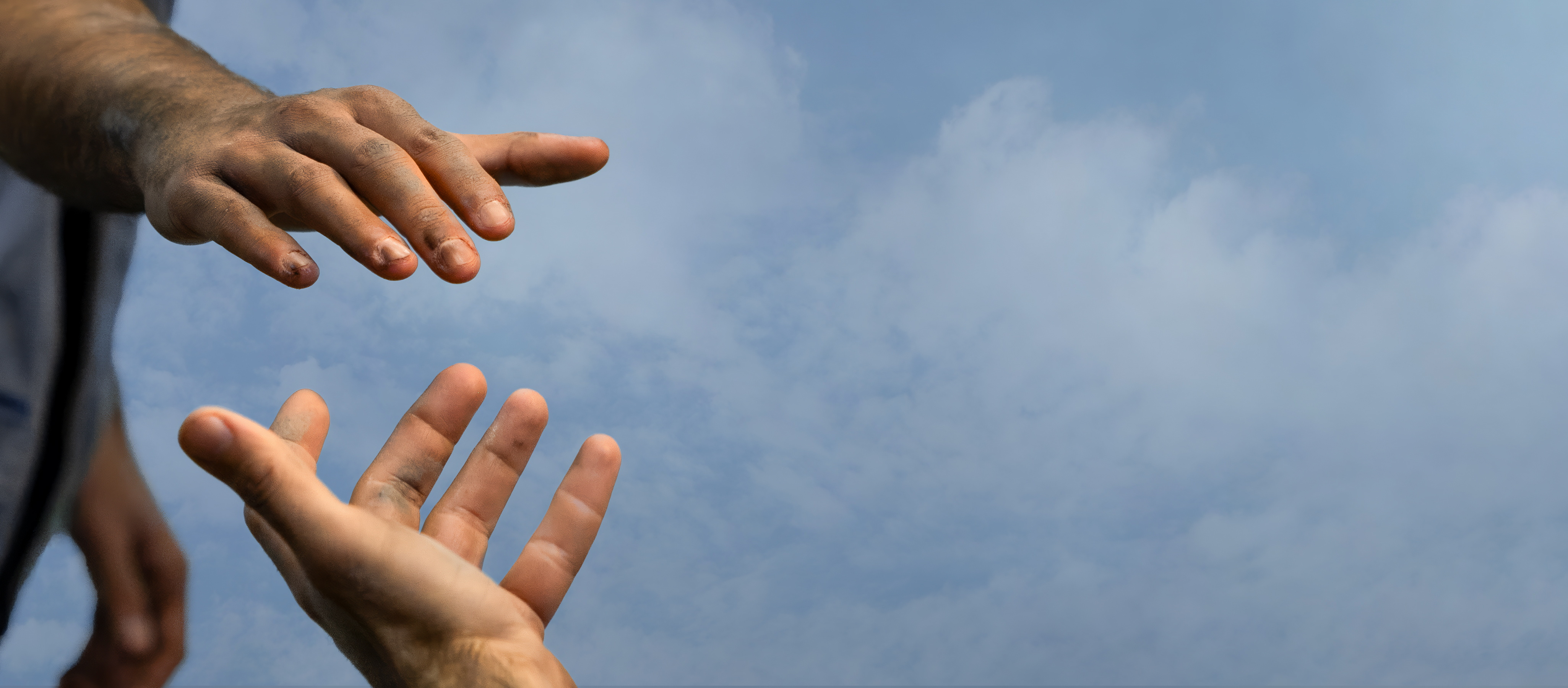 Två händer sträcker sig mot varandra.