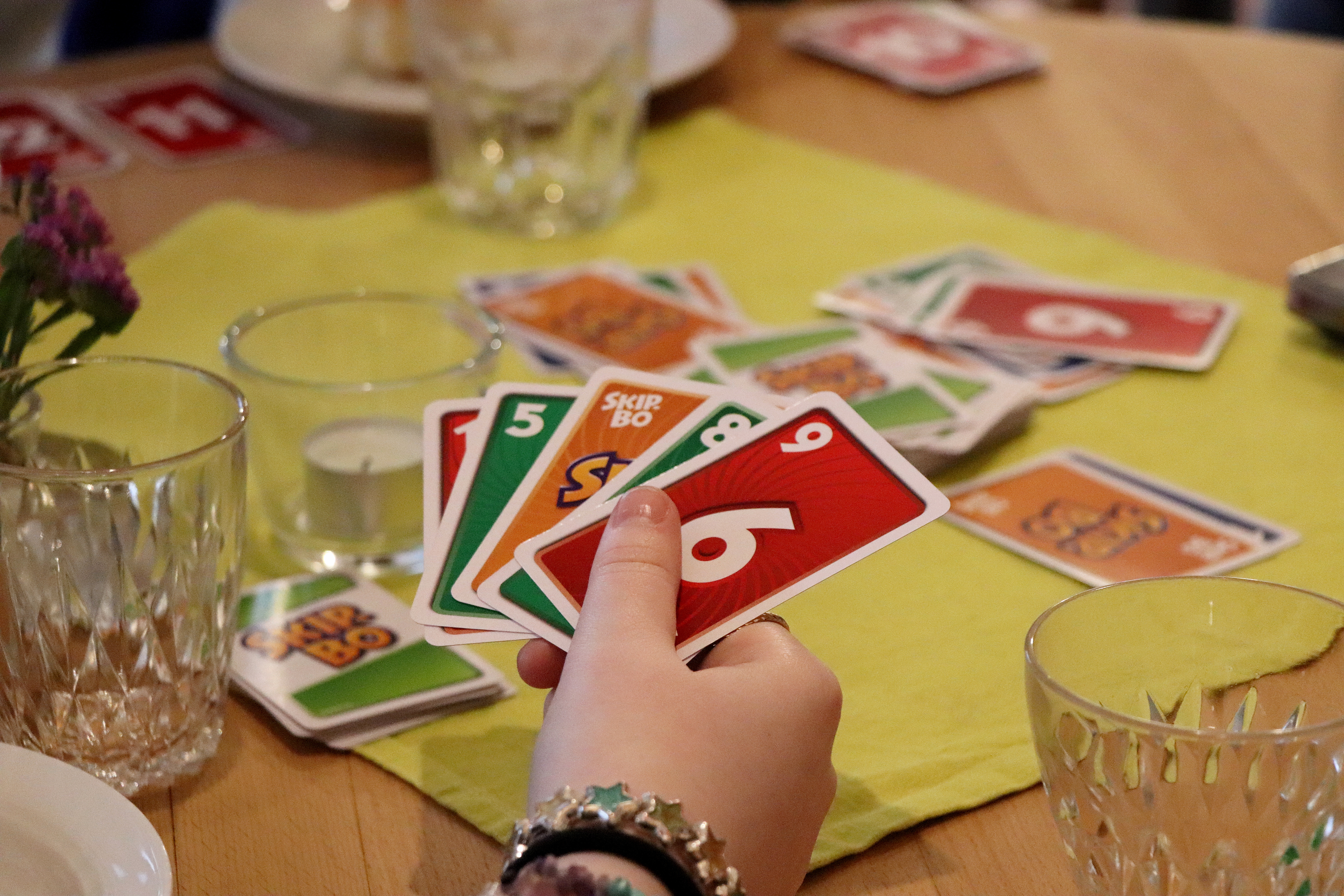 Händer som håller spelkort i olika färger.