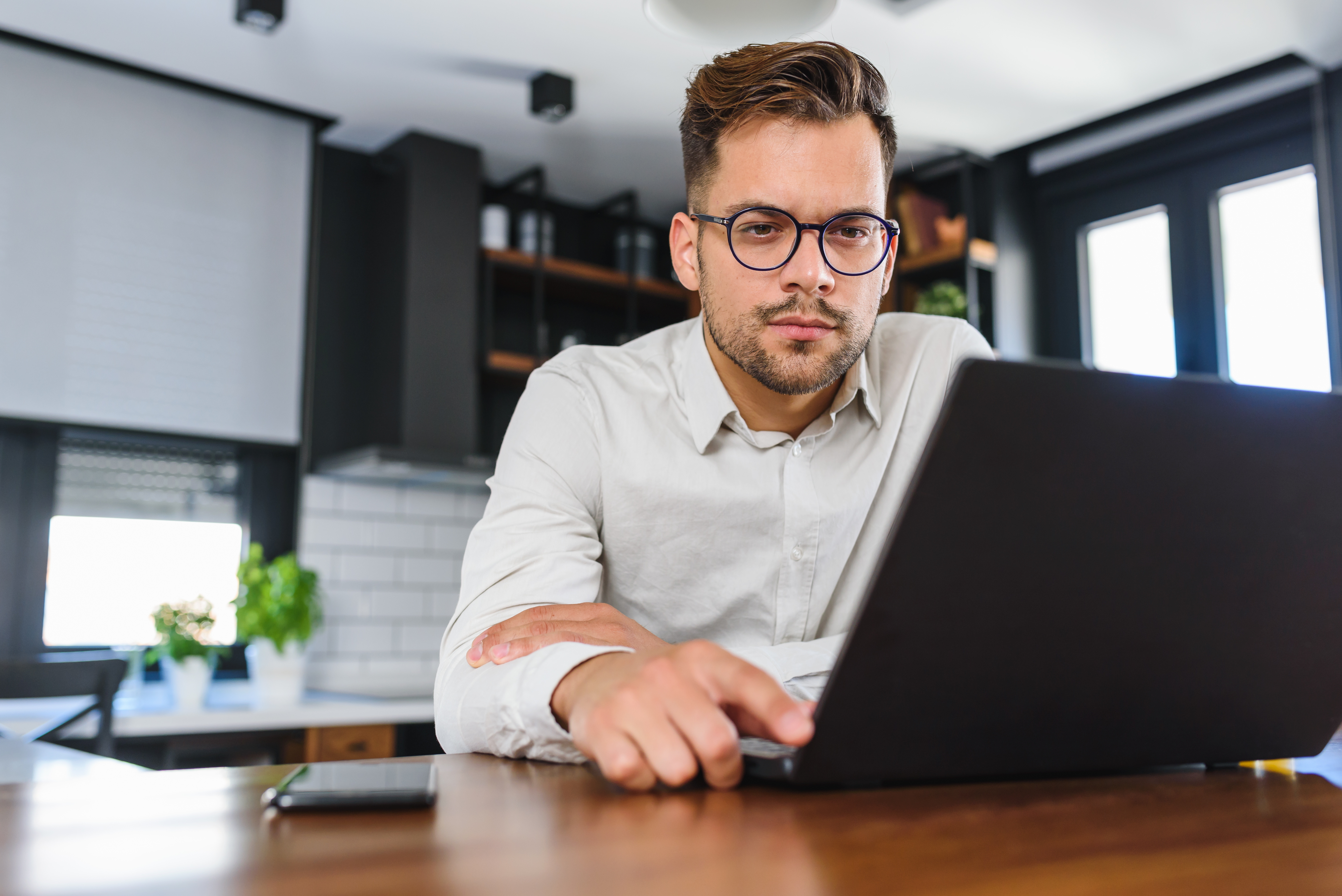 Ung man arbetar från datorn hemifrån.