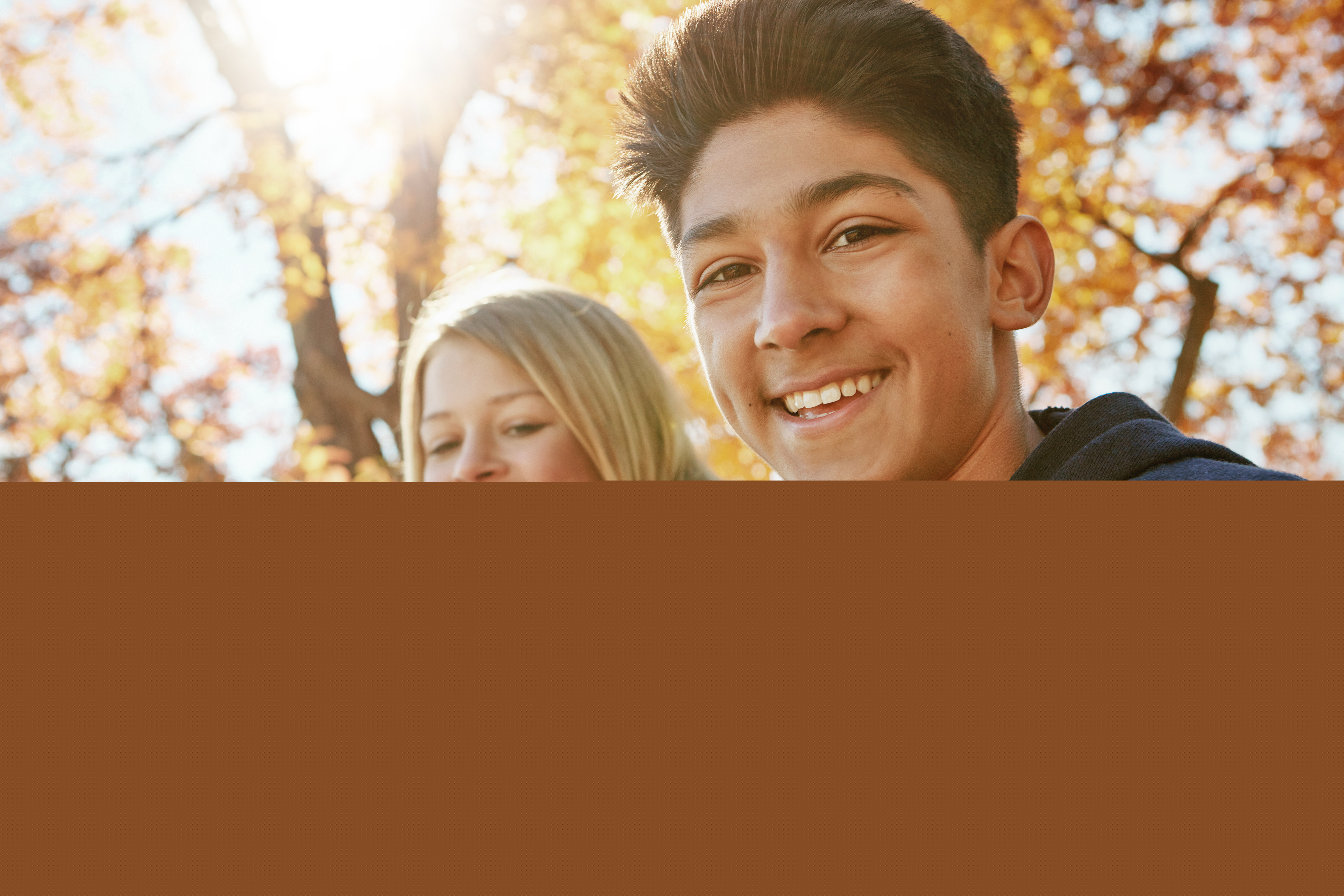 En grupp ungdomar samlade i en park på hösten.