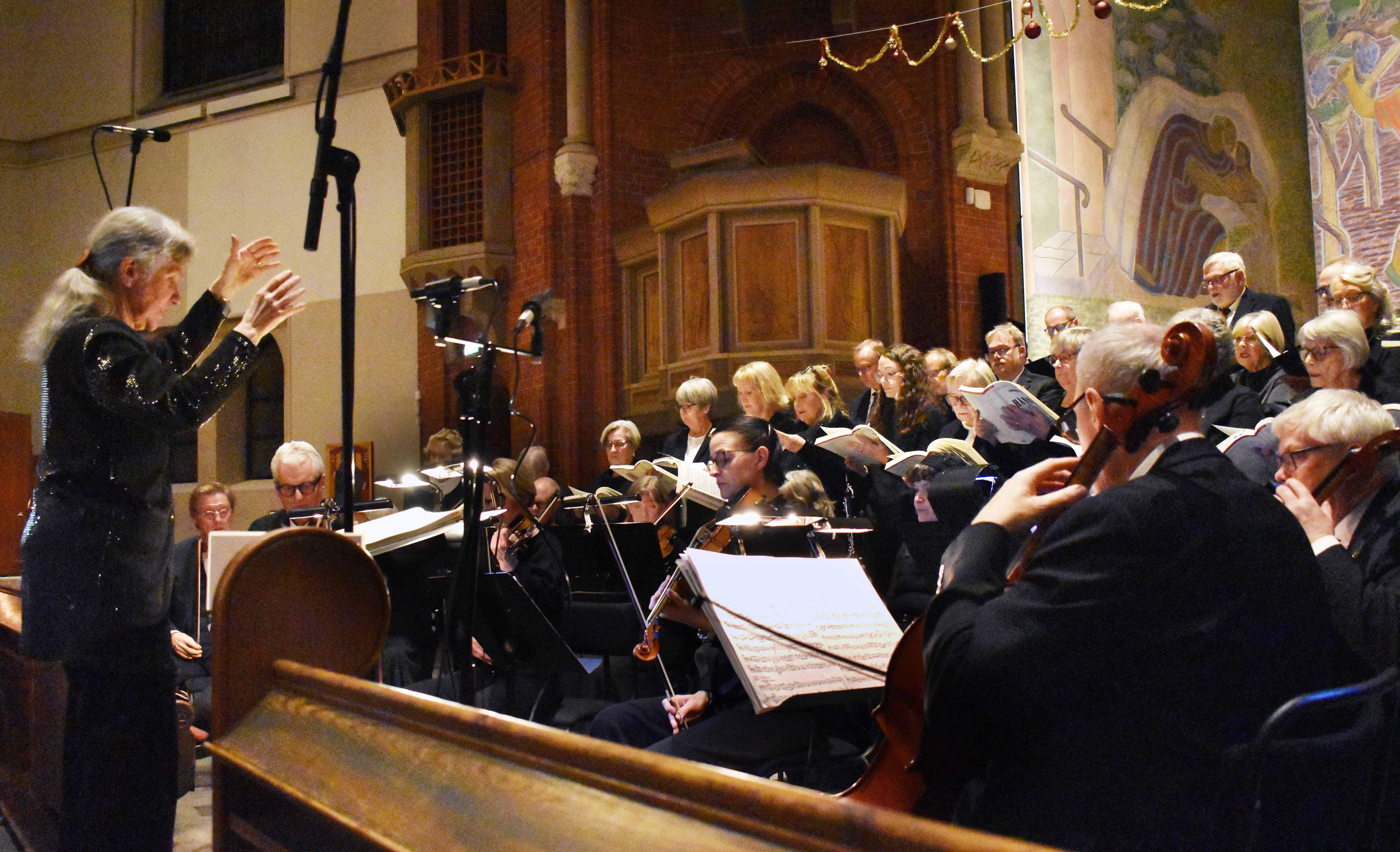 Kör och orkester under konsert i kyrka.