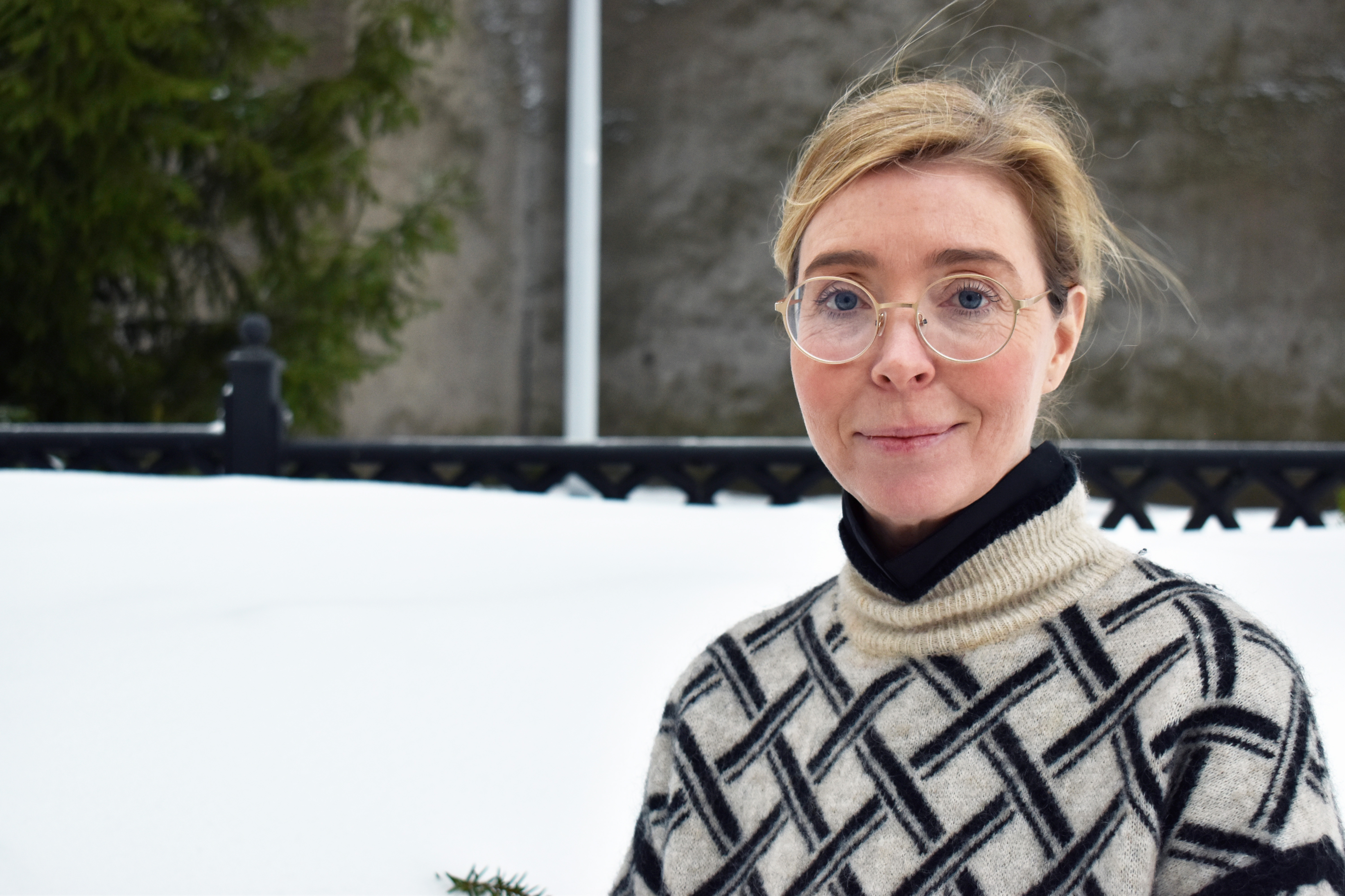 Kvinna med runda glasögon utomhus vintertid.